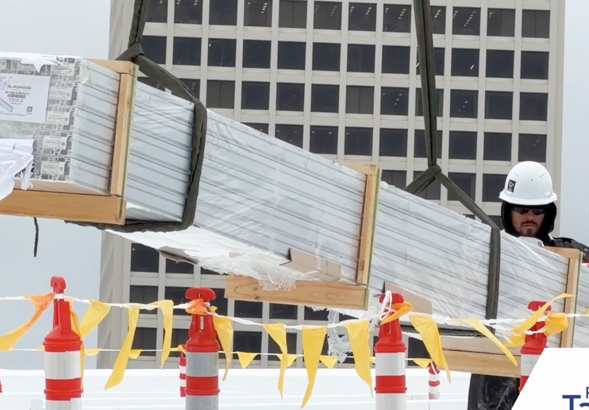 Video still of a construction worker installing solar panels. 